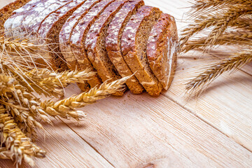 Whole wheat bread. Fresh loaf of rustic traditional bread with wheat grain ear or spike plant on...