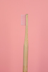 cepillo de dientes de bambú color rosa con fondo liso color rosa