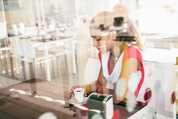 Young beauty woman in bar drinking coffee