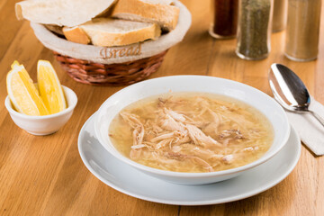 Bowl of chicken soup. Chicken soup in a white plate on wooden table.