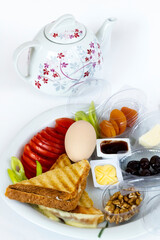 Traditional Turkish Breakfast Plate with boiled egg and tea on white surface.Top view