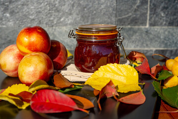 Nectarine jam and fresh nectarines. Homemade nectarine jam with fresh organic nectarines on wooden rustic background. Selective focus. 