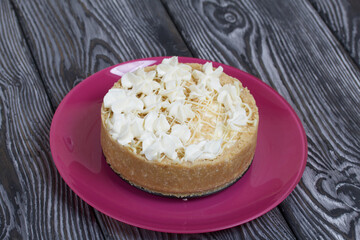 Cheesecake with white chocolate. On pine planks painted black and white.