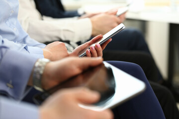 Group millennial business people hold mobile device in hand closeup using wifi background