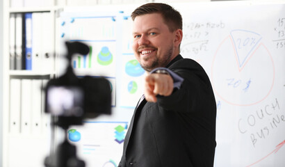 Male in suit and tie show stats graph pad making promo videoblog or photo in office camcorder to tripod portrait. Vlogger selfie solution or finance advisor management information professional concept © H_Ko