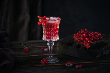 Glass of red currant cocktail or mocktail, refreshing summer drink with crushed ice and sparkling...