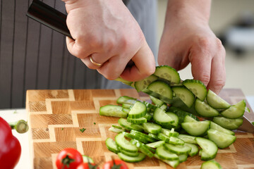 Culinary Male Chopping Green Dieting Cucumber. Chef Cutting Fresh Organic Cuke on Wooden Board at Kitchen. Sharp Knife Cut Ingredient to Small Slices. Healthy Food Concept Horizontal Photography