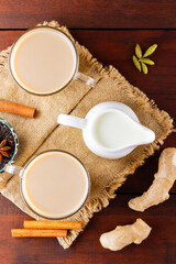 Masala chai tea on burlap. Traditional indian drink - masala tea with spices on a wooden background. Top view