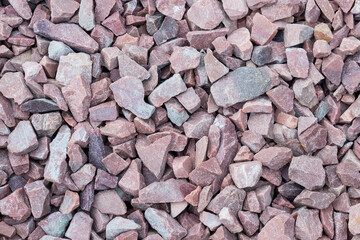 Full frame of reddish decorative stone stack. Stones for garden decoration as background 