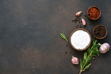 Fototapeta na wymiar Peppercorns, garlic and fresh rosemary on a concrete background.