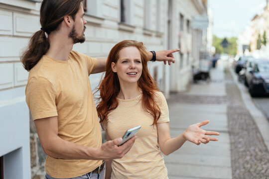 Young couple standing chatting in town