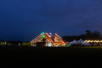 Night view of a circus tent under a blue hours sunset and clean blue sky