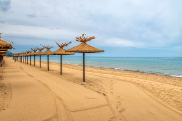 Beauty wooden umbrellas of empty sandy beach
