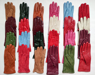 Collection of colored fashionable various leather gloves on a light background.