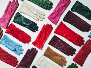 Collection of colored fashionable various leather gloves on a light background.