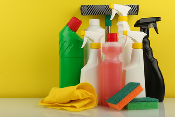 group of cleaning and detergent products on yellow background