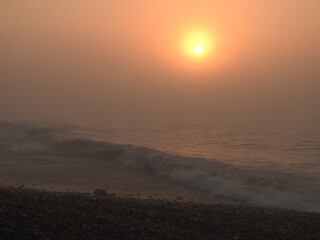 Sunset over the sea in fog