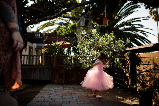 Young girl in tutu dress playing in front yard