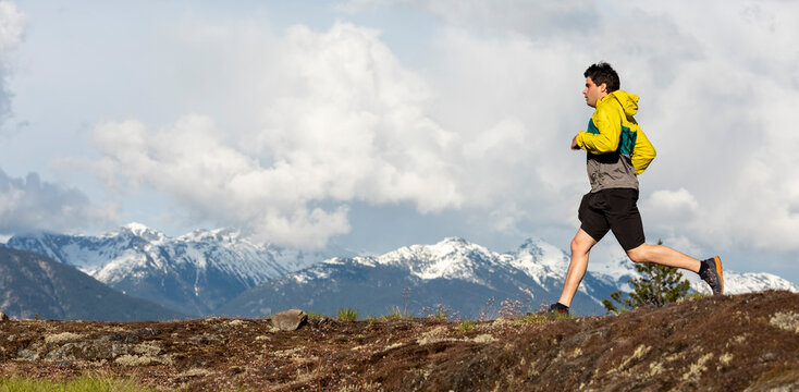 Man trail runs on a scenic alpine mountain trail in British Columbia.