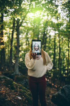 Pretty girl poses in nature with tablet