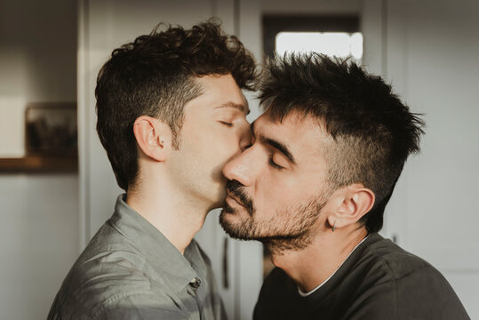 Gay boys couple hugging and kissing in the room. LGBT