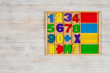 Multicolored numbers and counting sticks for studying the account in a box on a wooden white...