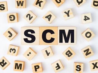 Supply Chain Management (SCM) is an abbreviation made of wooden cubes. Finance concept.