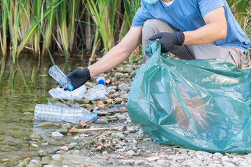 Close Up of Person Collecting Plastic From the River.