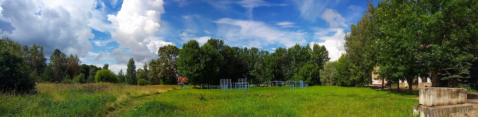 View of a green lawn with trees with a colorful blue sky.