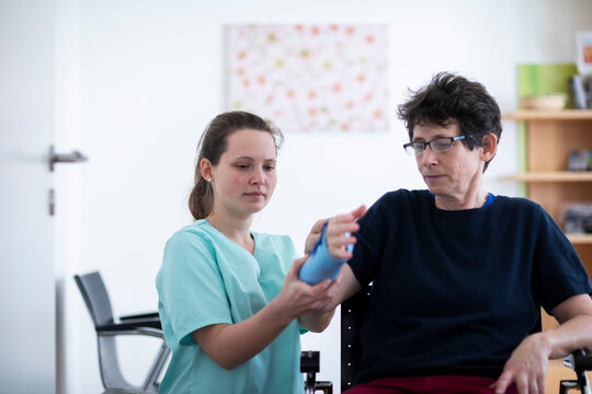 nurse tigthing a armbracer to a patient female