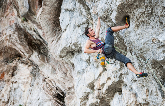 young man climbing overhang in Yangshuo / China