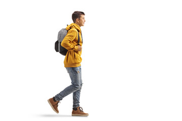 Fototapeta Full length profile shot of a male teenage student in a yellow hoodie walking obraz