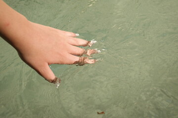 woman's hand in the river stream