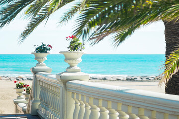 Stunning views of the azure water of the Mediterranean Sea, waves, sand, palm trees and a romantic line of balustrades with antique vases near the European hotel. Benicassim Beach,Spain.Summer holiday
