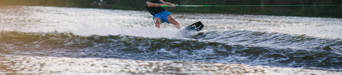 Man on a wakeboard in the river at daytime