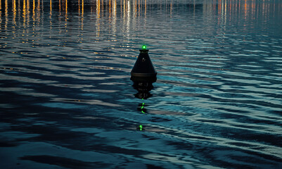 View of the blue dark waters of the river and the buoy, which sways on the waves. buoy sways in twater as safety warning and navigation marker at harbor or port
