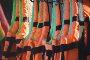 A stack of orange life jackets hanging on a hanger