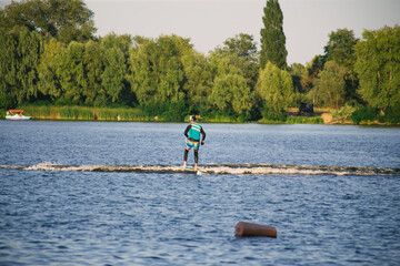 Man on a wakeboard in the river at daytime