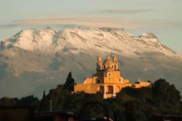 Remedios church and pyramid of cholula with iztaccihuatl volcano in the background at sunrise