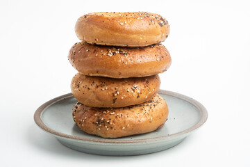 A Stack Of Four "Everything" Bagels On Ceramic Breakfast Plate