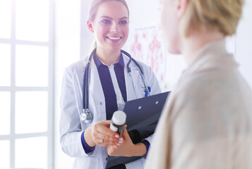 Doctor and patient discussing something while sitting at the table . Medicine and health care concept