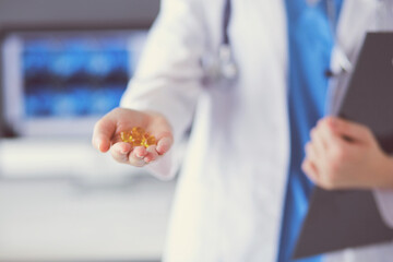 Close-up shot of doctor's hands holding pills at clinic.