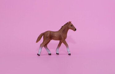 Plastic toy horse figure isolated on pink background