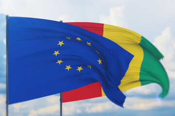 Waving European Union flag and flag of Guinea. Closeup view, 3D illustration.