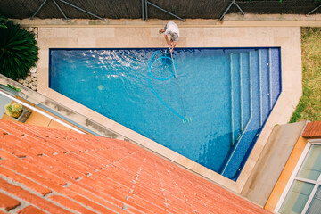 top view of man cleaning a swimming pool
