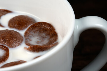 Macro view of chocolate cereals in milk.