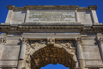 Obraz premium Right next to Colosseum stands Arch of Constantine, erected in early fourth century to celebrate victory of Constantine over Emperor Maxentius. Arch decorated with statues and reliefs. Rome. Italy.