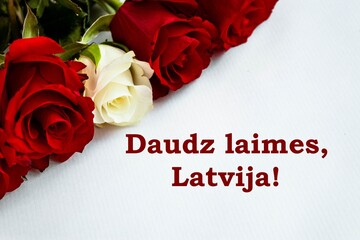 Red and white roses in colors of Latvian flag on white background with congratulatory message "Great happiness, Latvia!" on the right side.