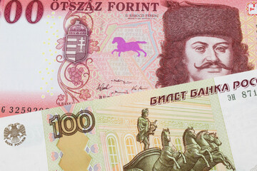 A macro image of a Russian one hundred ruble note paired up with a red and white five hundred forint note from Hungary.  Shot close up in macro.