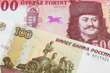 A macro image of a Russian one hundred ruble note paired up with a red and white five hundred forint note from Hungary.  Shot close up in macro.